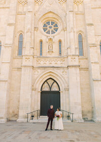 Newlywed couple standing in front of San Fernando Cathedral in downtown San Antonio after their wedding ceremony.