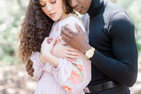 Romantic engagement portrait of a couple embracing outdoors in soft natural light.