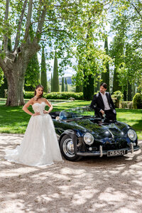 Editorial bride in couture lace gown beside vintage Porsche at private chateau in Provence - captured by editorial wedding photographer Paris L'Atelier Plez