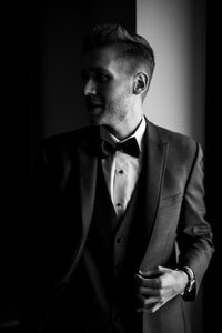 Dramatic black and white portrait of a groom in a tuxedo at an Orlando wedding