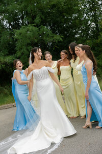 sprintime wedding with bride surrounded by her bridal party dressed in light blues and greens