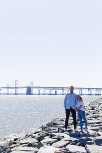 A glossy photograph taken by Studio Roscher of a happy engaged couple seaside in Richmond, VA