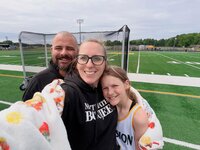 Emily, the photographer of Studio Roscher, smiling with her husband and daughter after a field hockey game