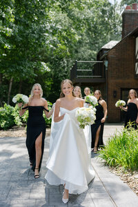bride walking through the garden at her ohio wedding venue with her bridesmaids