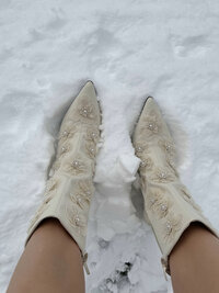 Powder - Ornate cream boots standing in fresh winter snow - TVS