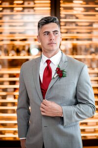 Groom in a grey suit and red tie at a luxury Orlando wedding