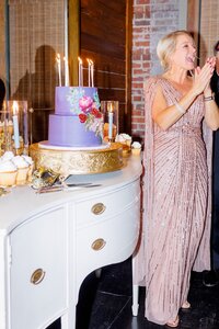 A photo taken by Studio Roscher of an event with a female smiling and clapping at her birthday party in Richmond, VA