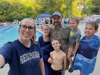 Emily, the photographer of Studio Roscher, smiling with her husband and kids at a swim meet