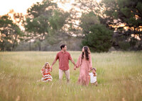 family-walking-through-meadow-bespoke-family-photography