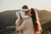 mother gently kissing her baby