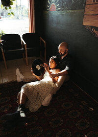 Couple listening to a vinyl record together during an in-home family session photographed by Angie Rich Photography in San Antonio.