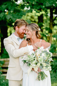 Bride and groom embracing each other during wedding photos on their wedding day.