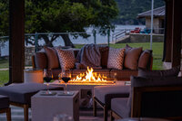 Serene outdoor lake view after sunset, warm cozy firetable vibes