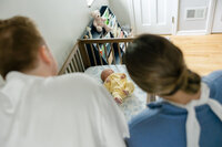over the shoulder look at newborn baby in their crib