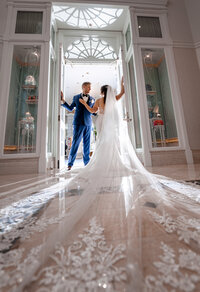 Bride with a long train and groom in a bright corridor at an Orlando wedding venue
