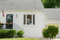 couple standing in the window holding their newborn baby