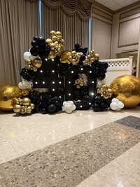 black gold and white balloons and backdrop