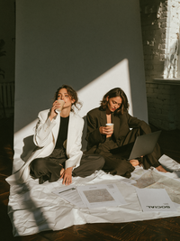 u6512682322_two_women_sit_cross_legged_on_a_large_white_backd_c5023a3f-0c6f-4e96-9d05-a193ffe8d1e5_2