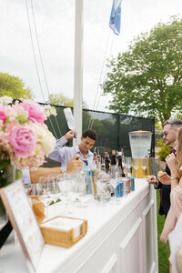 Bartender at the Sconset Casino pouring a wedding guest a drink.