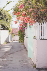 Charming Mediterranean street with white walls, pink bougainvillea, and coastal architecture