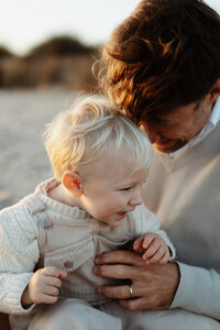 papa et son petit garçon qui jouent à la plage