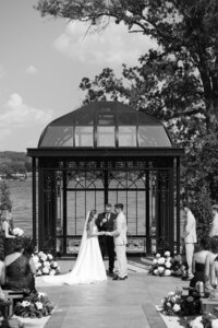 black and white image of bride and groom standing in front of ohio lake