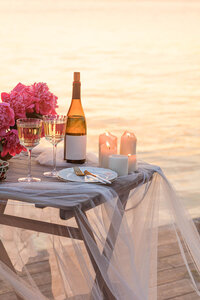 Seaside picnic table overlooking the Amalfi Coast at sunset, with wine, food, and Mediterranean views