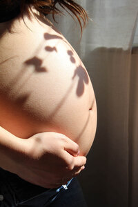 pregnant woman with floral shadows on belly