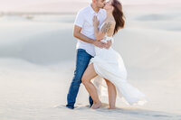 Couple sharing an embrace on the desert dunes, Palm Springs photography session