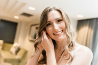 Getting ready photo of bride putting on earrings captured by wedding photographers