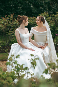 Two brides together in their wedding dresses on their wedding day