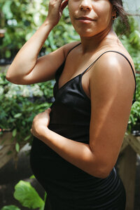 A mother holds her pregnant belly during her maternity photos in houston texas