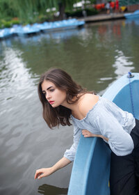 woman-leaning-from-blue-boat-melbourne-lake-portrait