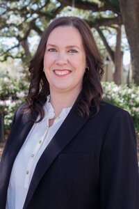 A classic professional portrait taken by Studio Roscher of a female professional smiling in a park