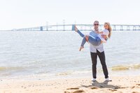 A glossy photograph taken by Studio Roscher of a happy engaged couple seaside in Richmond, VA