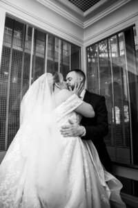 Black and white photo of a bride and groom kissing at their Orlando wedding