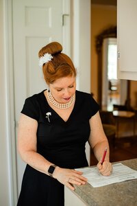 Officiant with Weddings & Events by Raina signs the marriage license