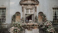bride and groom standing on balcony