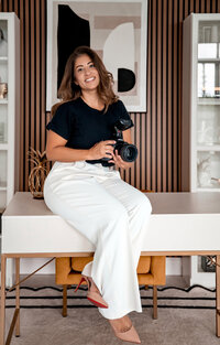 Orlando family photographer Andrea Napoli-Wilson holding her camera in a modern studio