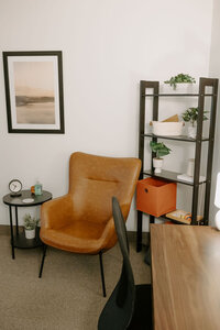 leather chair in front of shelf and near desk and chair.