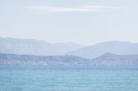 Corfu Dreams - Coastal city nestled between sea and mountains in haze - TVS