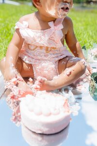 A glossy photograph taken by Studio Roscher of a sad birthday girl with cake outside in a park in Richmond, VA