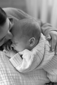 mother cuddling her newborn during in-home photography session