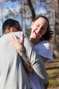 A glossy photograph taken by Studio Roscher of a happy engaged couple outside in a park in Richmond, VA