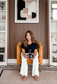 Andrea of Bella Grey Photography seated with her camera in the Orlando studio