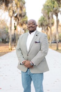 A classic professional portrait taken by Studio Roscher of a male professional smiling in a park