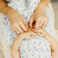 A close up photo of a mothers hands and her daughters hands during an in home photography session in Wilmington, North Carolina