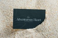 Adventurous Heart Therapy custom brand identity displayed on textured printed collateral