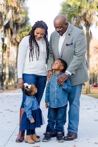 A glossy photograph taken by Studio Roscher of a happy family outside in a park in Savannah, GA