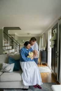 father and mother holding their baby during in-home newborn photography session